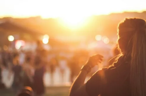 photo of a girl seen from the back in a festival during sunset