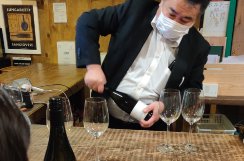 a japanese man opening a bottle of wine