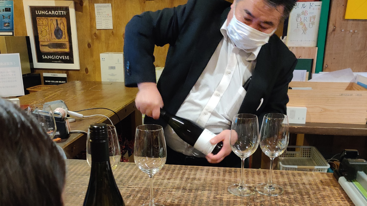 a japanese man opening a bottle of wine